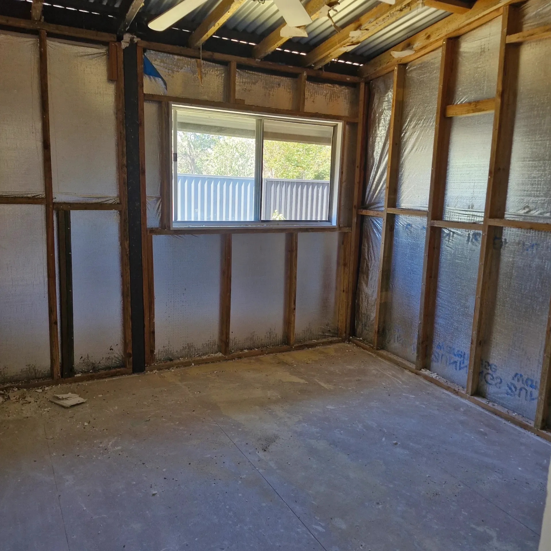 Interior room stripped back to wall framing and exposed ceiling joists