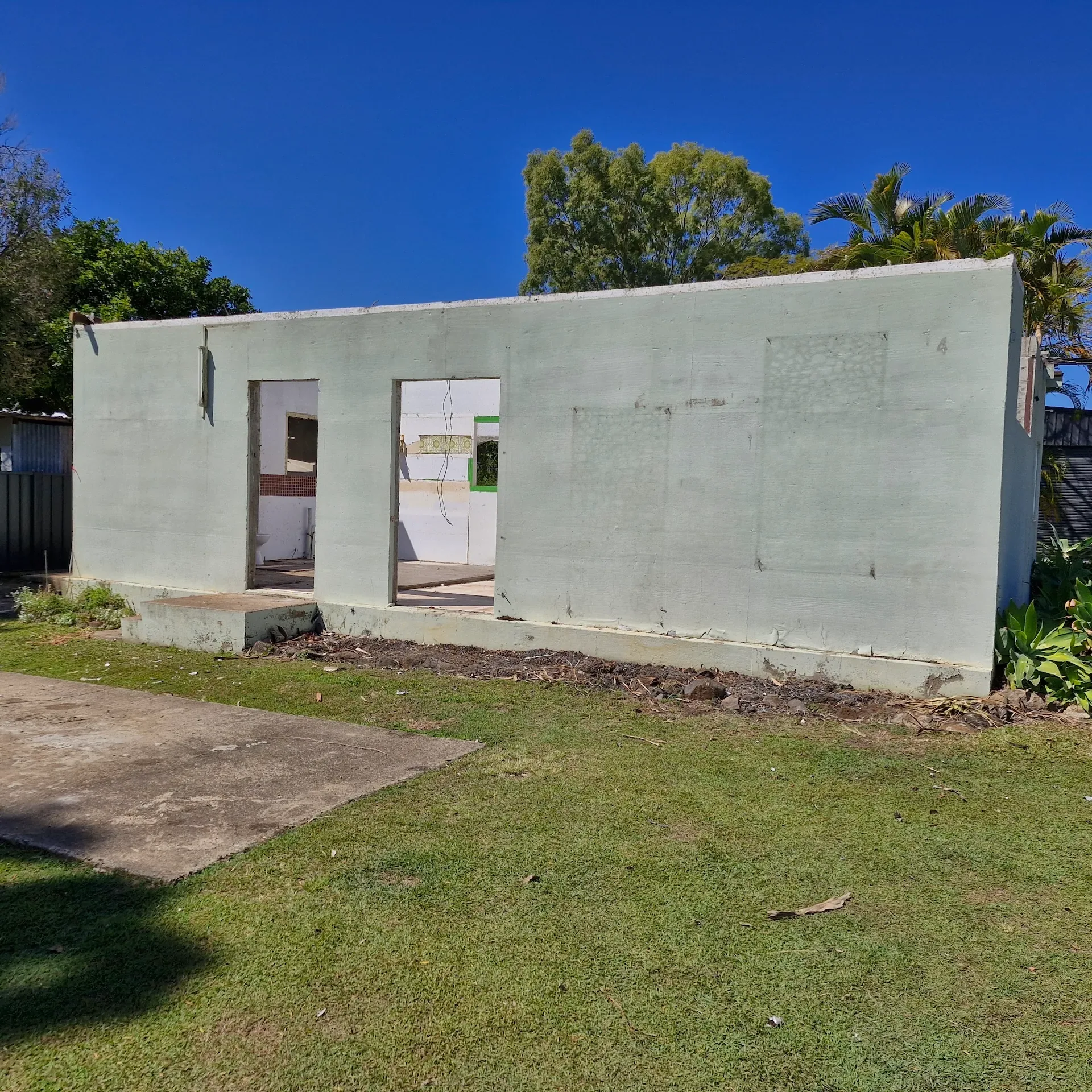 Partially demolished masonry house with only exterior walls remaining