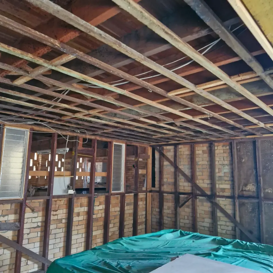 Interior room stripped back to exposed wall studs and ceiling framing