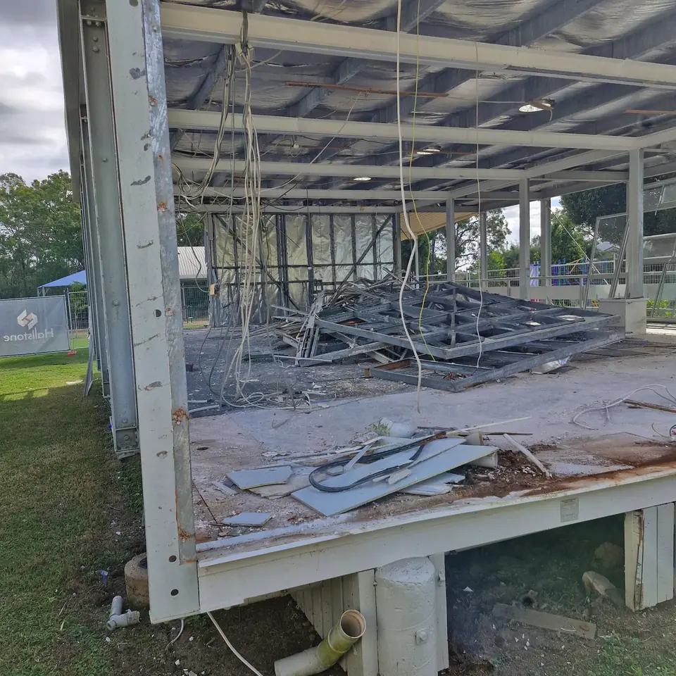 Partially stripped building with exposed framing, floor and demolition debris