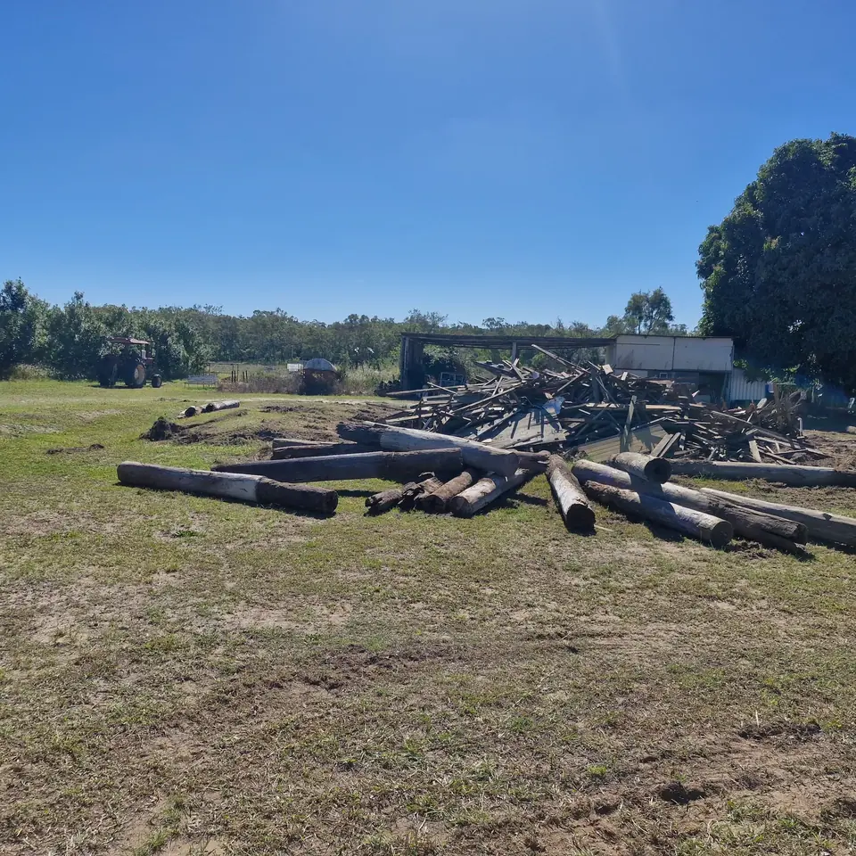 Pile of removed timber and demolition debris on an open cleared site